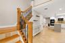 Hardwood staircase featuring wrought iron balusters and tiled risers