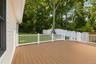 Expansive outdoor deck featuring wood-finish flooring and white railings