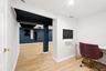 Versatile finished interior basement  space featuring wood-finish flooring, recessed lighting, and a white wall-mounted monitor
