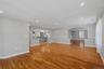 Spacious family room area featuring wood-finish flooring, recessed lighting, and a neutral color palette