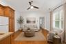 Open concept bonus room area featuring kitchenette wood-finish flooring, a vaulted ceiling, and a ceiling fan