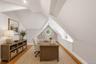 Attic space featuring pitched ceilings, wood-finish flooring, built-in recessed lighting, and a built-in window seat with cabinetry