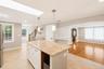 Central kitchen island with a light-toned granite countertop and white cabinetry