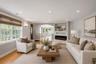 Bright living space featuring wood-finish flooring, recessed lighting, and an integrated electric fireplace with shelving above