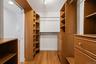 Walk-in closet featuring wood-finish flooring, recessed lighting, track lighting, and built-in shelving units