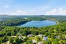 Aerial perspective showcasing a large body of water surrounded by expansive green landscapes and residential properties