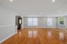 Spacious family room area featuring wood-finish flooring, recessed lighting, and a neutral color palette
