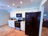 Kitchen featuring white shaker-style cabinetry, dark appliances, recessed lighting, and patterned tile flooring