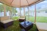 Screened outdoor enclosure featuring a fabric canopy, clear vinyl panels, and an artificial turf floor