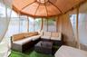 Outdoor gazebo structure with a beige fabric canopy, screen panels, and privacy curtains