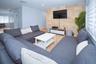 Living space featuring a stone veneer accent wall and tile flooring