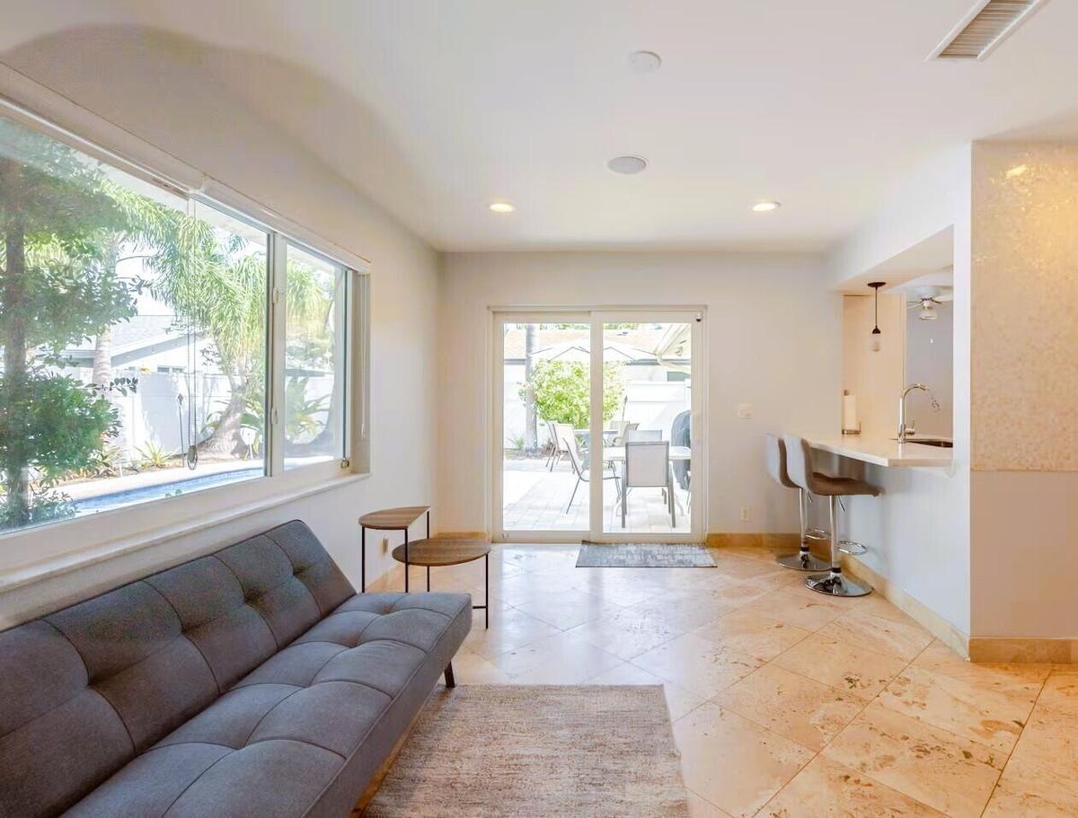 Open-concept living space featuring expansive windows, recessed lighting, and large format floor tile