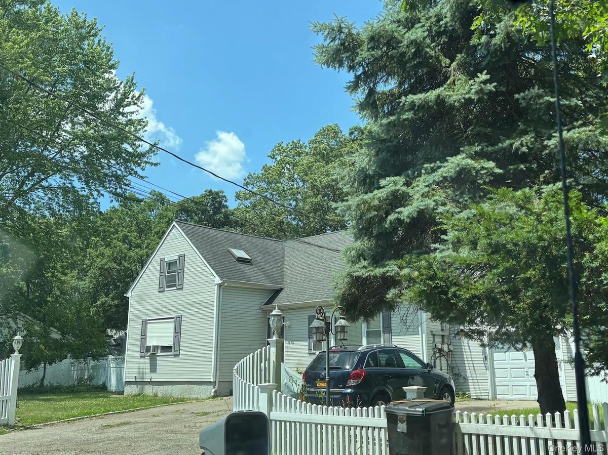 View of front of property featuring a shingled roof and driveway