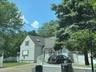 View of front of property featuring a shingled roof and driveway