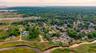 Aerial view of property and surrounding area featuring a nearby body of water and nearby suburban area
