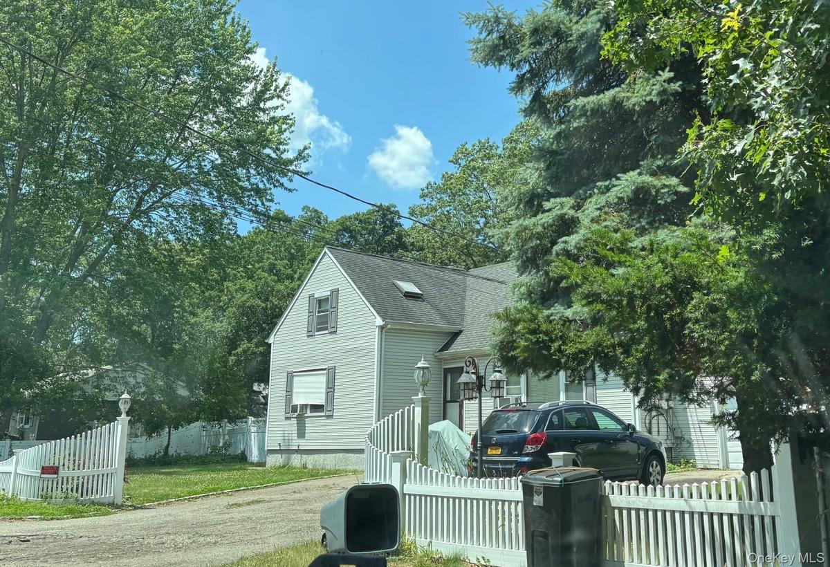 View of front of house featuring roof with shingles and a fenced front yard