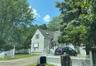 View of front of house featuring roof with shingles and a fenced front yard