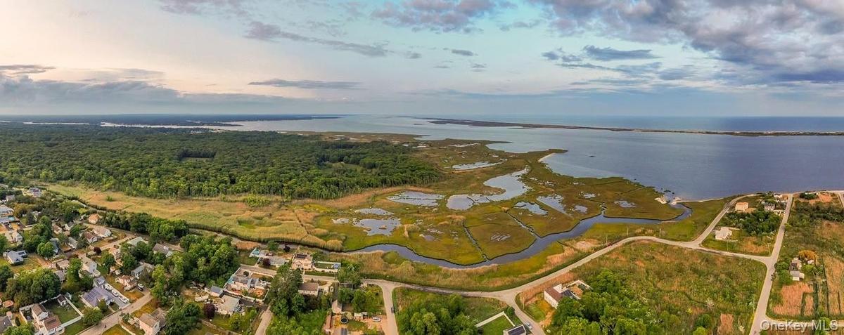Aerial view of property and surrounding area featuring a nearby body of water