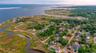 Aerial overview of property's location featuring a nearby body of water and nearby suburban area