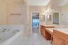 Primary bedroom ensuite with double vanity sinks, whirlpool bath, separate shower and toilet.