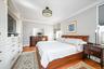The king-size primary bedroom features custom built in cabinetry for substantial added storage, and a large private decked balcony with open views tow
