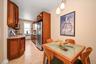 Eat in chef’s kitchen includes wood cabinetry with soft close doors, a dedicated pantry, granite countertops, stone tile flooring, and top of the line