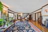 Spacious interior featuring hardwood flooring, detailed crown molding, a built-in fireplace, and double French doors with transom windows
