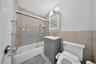 Full bathroom with tub/shower combination, vanity storage, and bidet