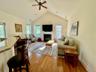 Spacious living room featuring a vaulted ceiling and wood-finish flooring and gas fireplace
