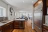 Kitchen featuring wood cabinetry, stainless steel appliances, granite countertops, and hardwood flooring