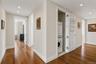 Hallway featuring wood-finish flooring, recessed lighting, and a stacked washer and dryer unit