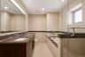 Bathroom featuring a dual vanity with integrated sinks, a built-in soaking tub, and a separate glass-enclosed shower