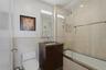 Bathroom featuring a dark wood-finish vanity with a single basin sink and wall-mounted mirror