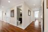 Hardwood flooring extends throughout this interior hallway, featuring recessed lighting and a white trim package