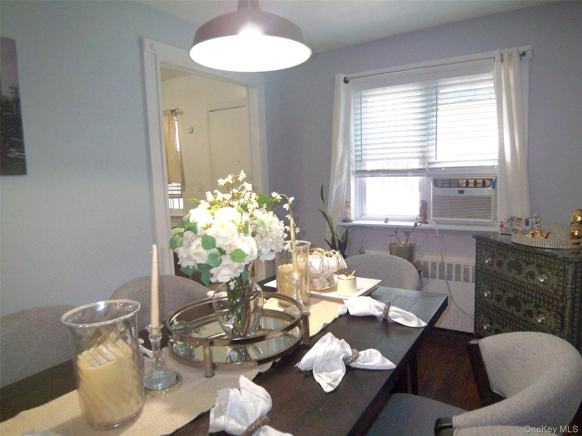 Dining area featuring a dark-finish rectangular table, overhead flush-mount lighting, light-toned wall paint, and a window with blinds