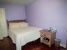 Room featuring rich wood-finish flooring and light lavender walls