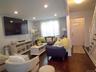 Living area featuring recessed lighting, dark wood-finish flooring, and a white front entry door with decorative glass inserts