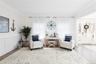 Living area with wood finished floors, ornamental molding, wainscoting, and a decorative wall