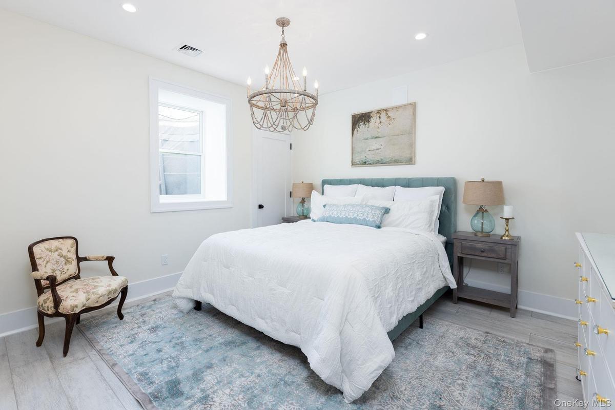 Bedroom with light wood-style floors, recessed lighting, and a chandelier