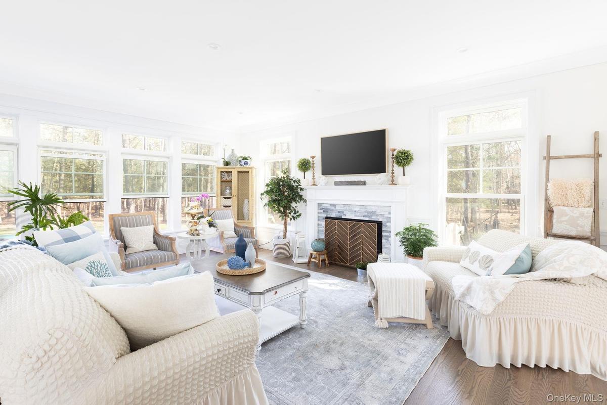 Living area featuring plenty of natural light, wood finished floors, and ornamental molding