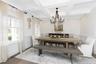Dining space with beam ceiling, wood finished floors, coffered ceiling, a chandelier, and wainscoting