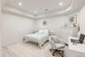 Bedroom with a raised ceiling, wood finished floors, and recessed lighting