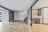 Indoor bar with stainless steel fridge, glass insert cabinets, ornamental molding, light wood-style flooring, and beverage cooler