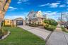 View of side of home with an outdoor structure, a yard, driveway, and a garage