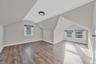 Bonus room with light wood-style floors and vaulted ceiling