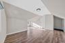 Bonus room featuring light wood-type flooring and lofted ceiling