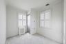Unfurnished bedroom featuring radiator heating unit, crown molding, multiple windows, and carpet