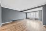 Unfurnished room featuring ornamental molding, baseboard heating, radiator, light wood-style flooring, and beam ceiling