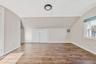 Additional living space featuring vaulted ceiling, wood finished floors, and arched walkways