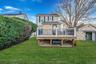 Back of property featuring a wooden deck, a lawn, and a chimney